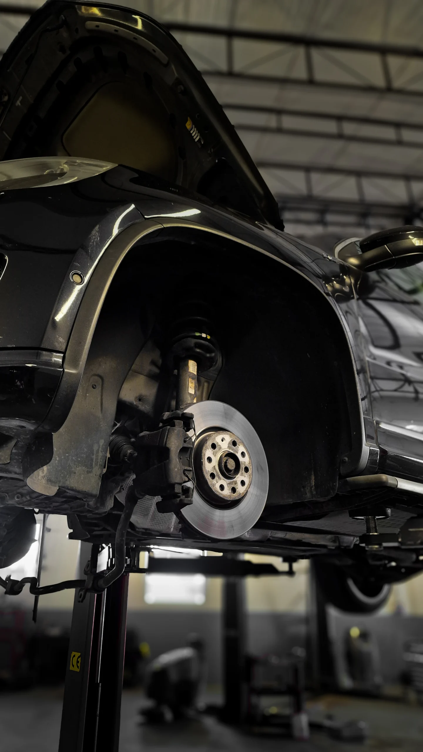 Exposed brake disc and caliper on a raised car