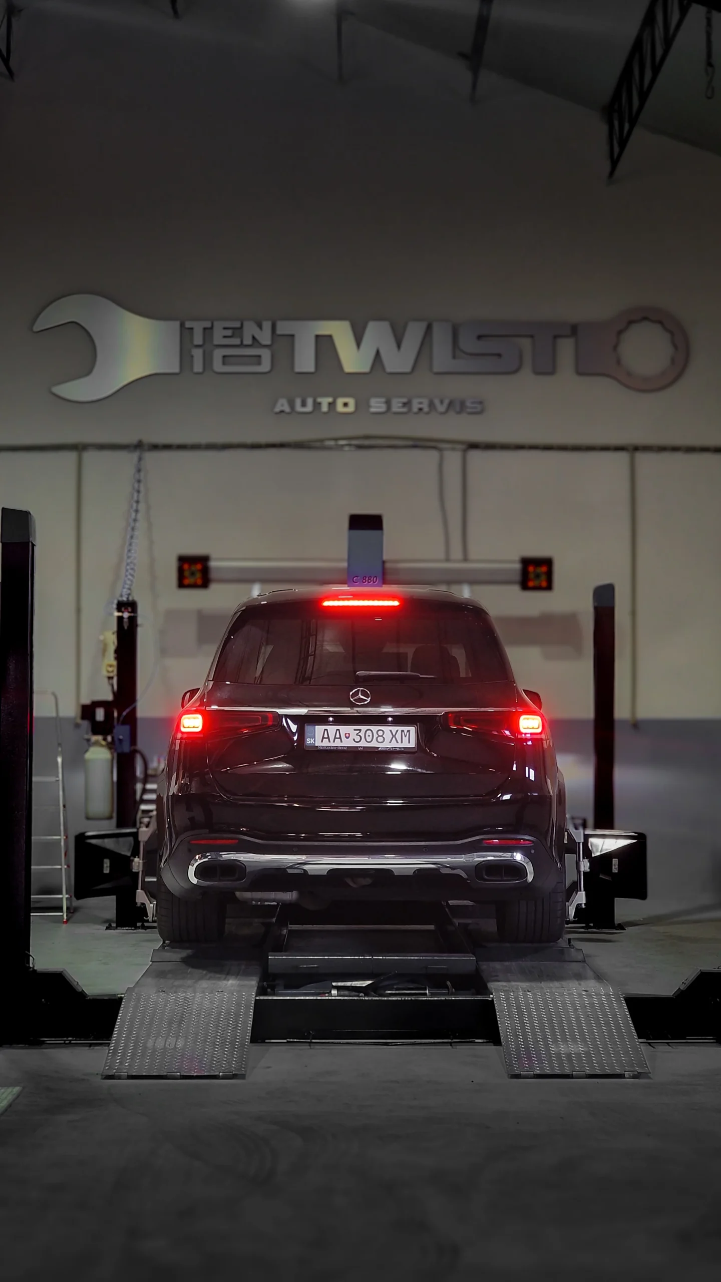 Rear view of an SUV on a workshop platform with its brake lights on