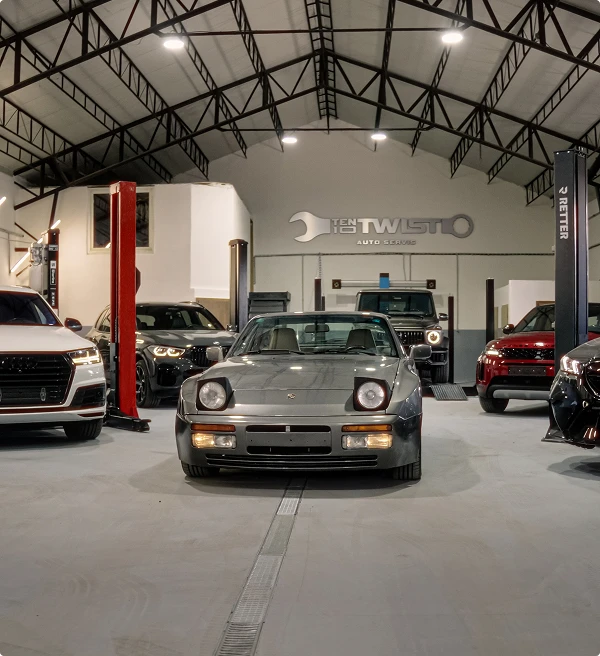 Grey sports car in front of other vehicles in the workshop